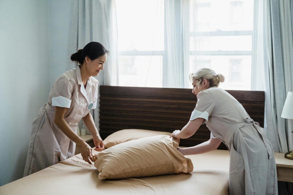 professional cleaner making Airbnb bed during same-day turnover on 30A
