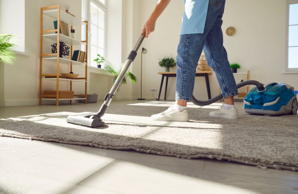 professional cleaner vacuuming sand from coastal home flooring