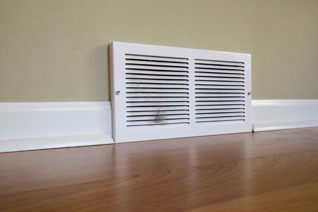 checking baseboards and air vents for moisture in coastal home